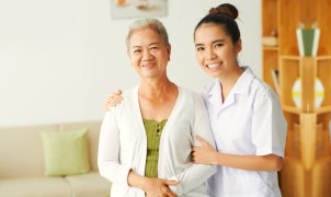 senior woman and caregiver smiling