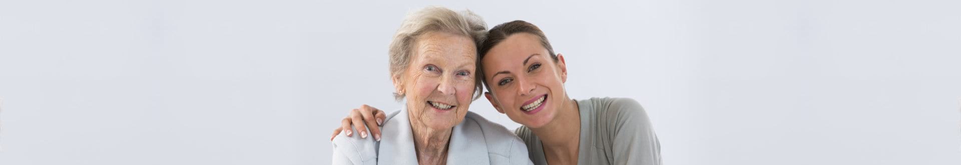 senior woman and caregiver smiling