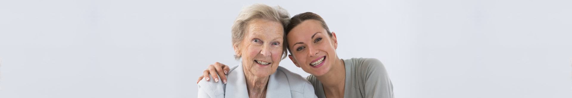 senior woman and caregiver smiling