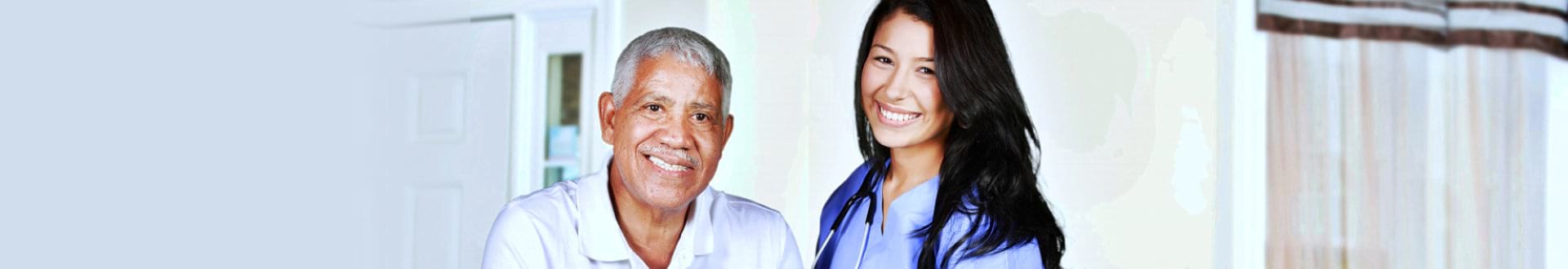 senior man with female caregiver smiling