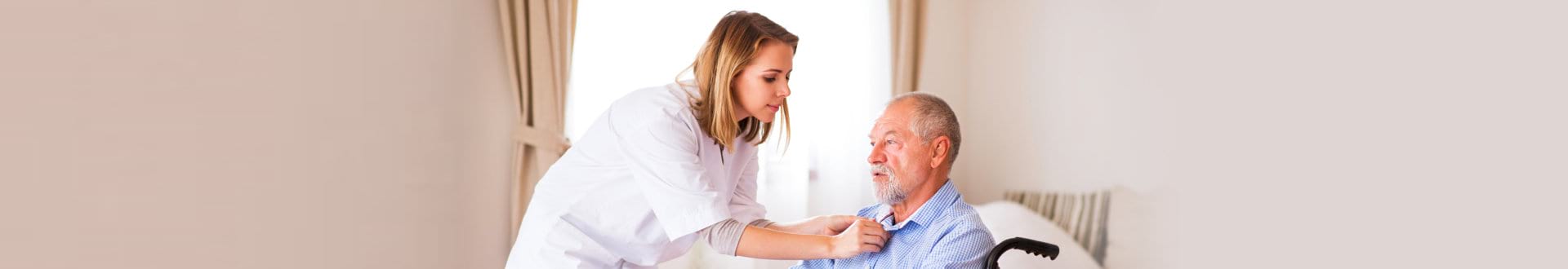 caregiver assisting senior man on bed